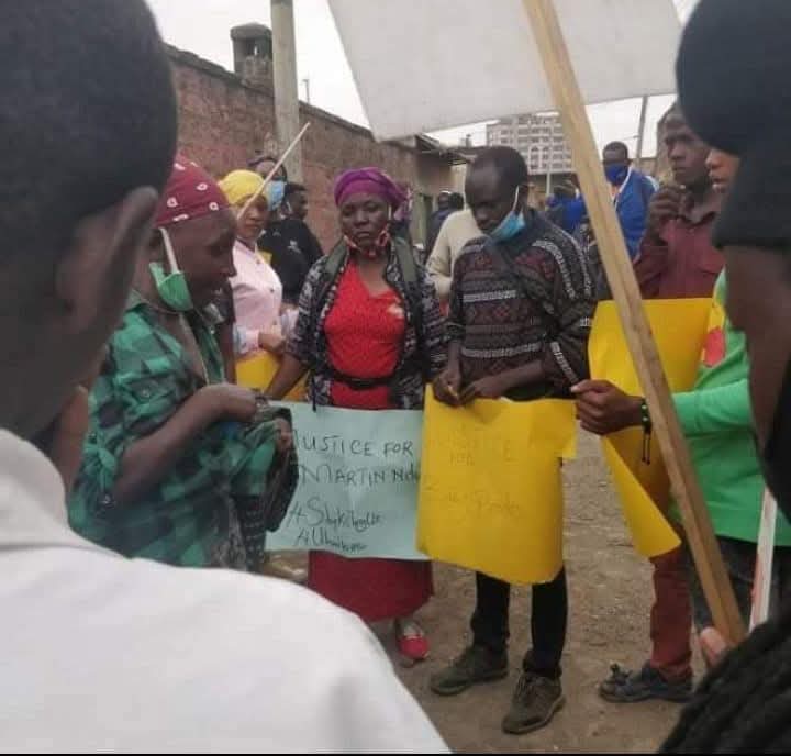 people in Kenya hold homemade signs saying "Justice for Martin"