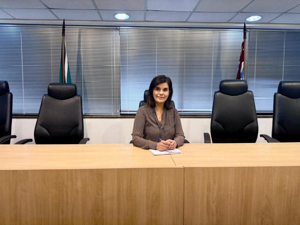 judge janaina sits at the judicial bench with a notepad and pen
